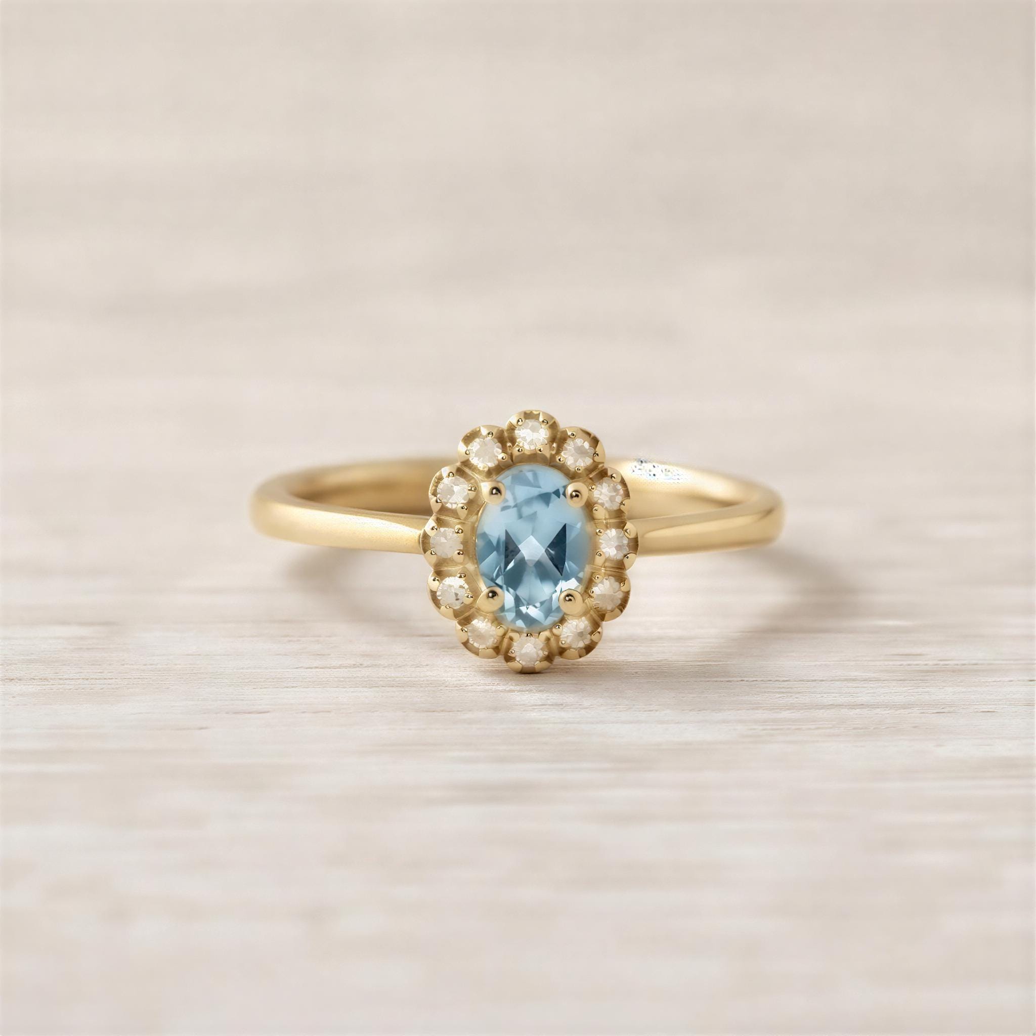 A gold ring with a blue gemstone, likely a diamond, set in the center.