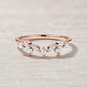 A rose gold ring with a halo of pearls and diamonds set in the center.