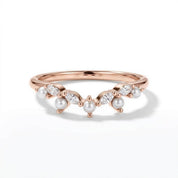 A rose gold ring with a band adorned with pearls and diamonds.