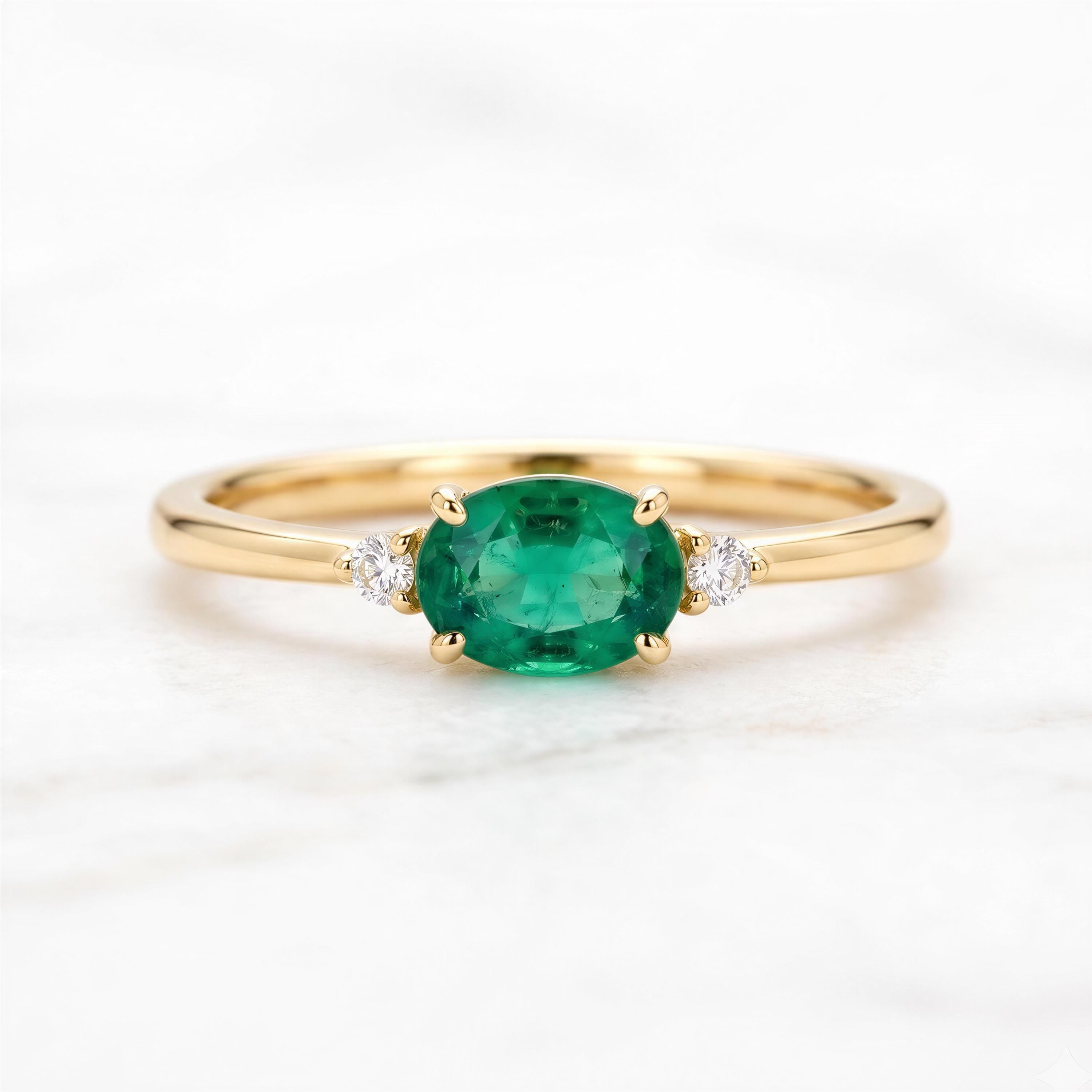 A gold ring with a large oval-shaped green gemstone in the center, surrounded by smaller diamonds.