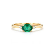 A gold ring with a large oval-shaped green gemstone in the center, surrounded by smaller diamonds.