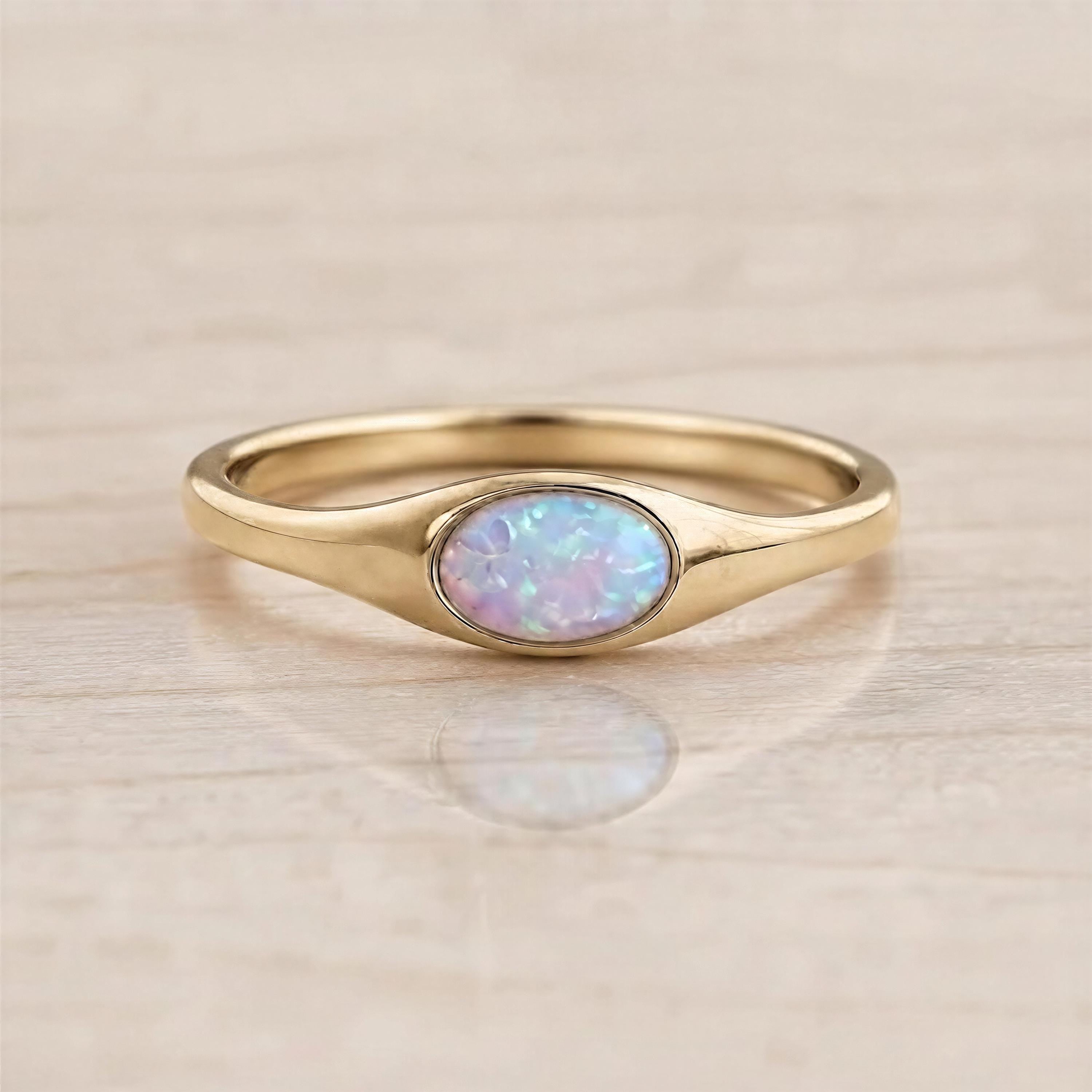 A gold ring with a large oval opal stone set in the center.