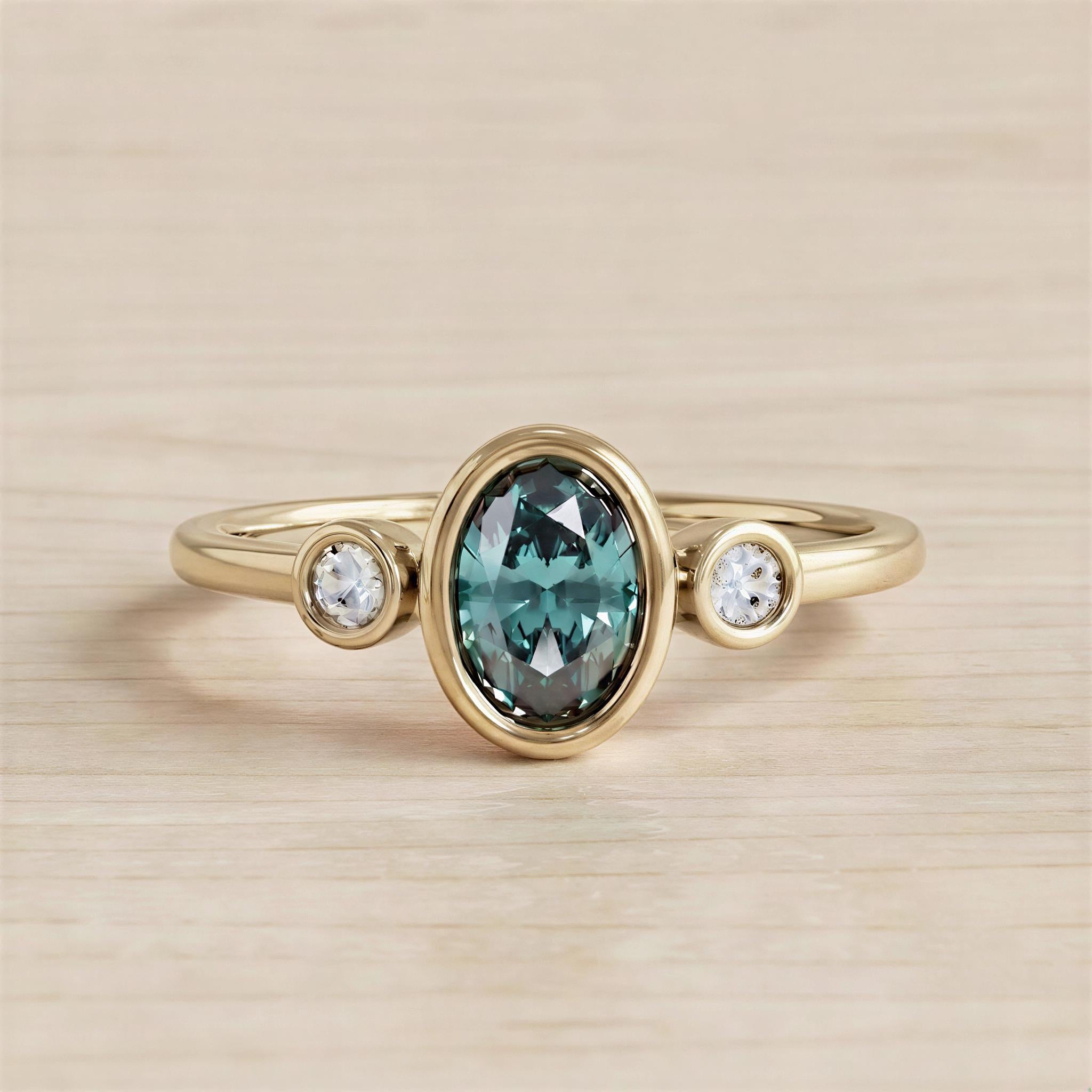 A gold ring with a large oval-shaped gemstone in the center, surrounded by smaller round stones.