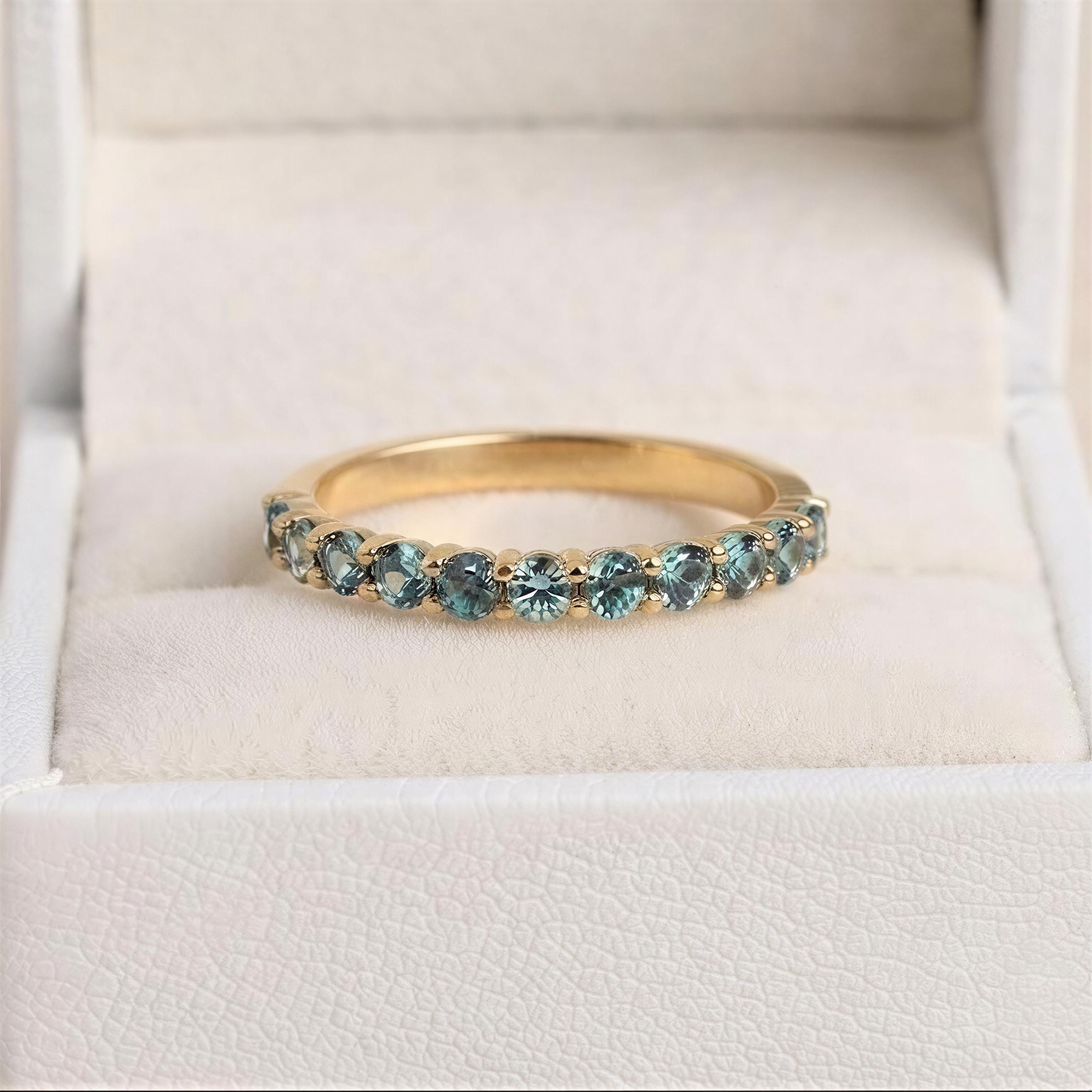 A gold ring with a row of blue sapphires set in the band.