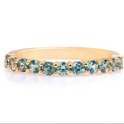 A gold band with a row of blue gemstones, including aquamarine and diamond-like stones, set in the center.