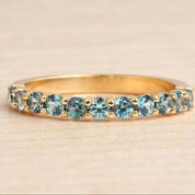 A gold ring with a row of blue sapphires set in the band.