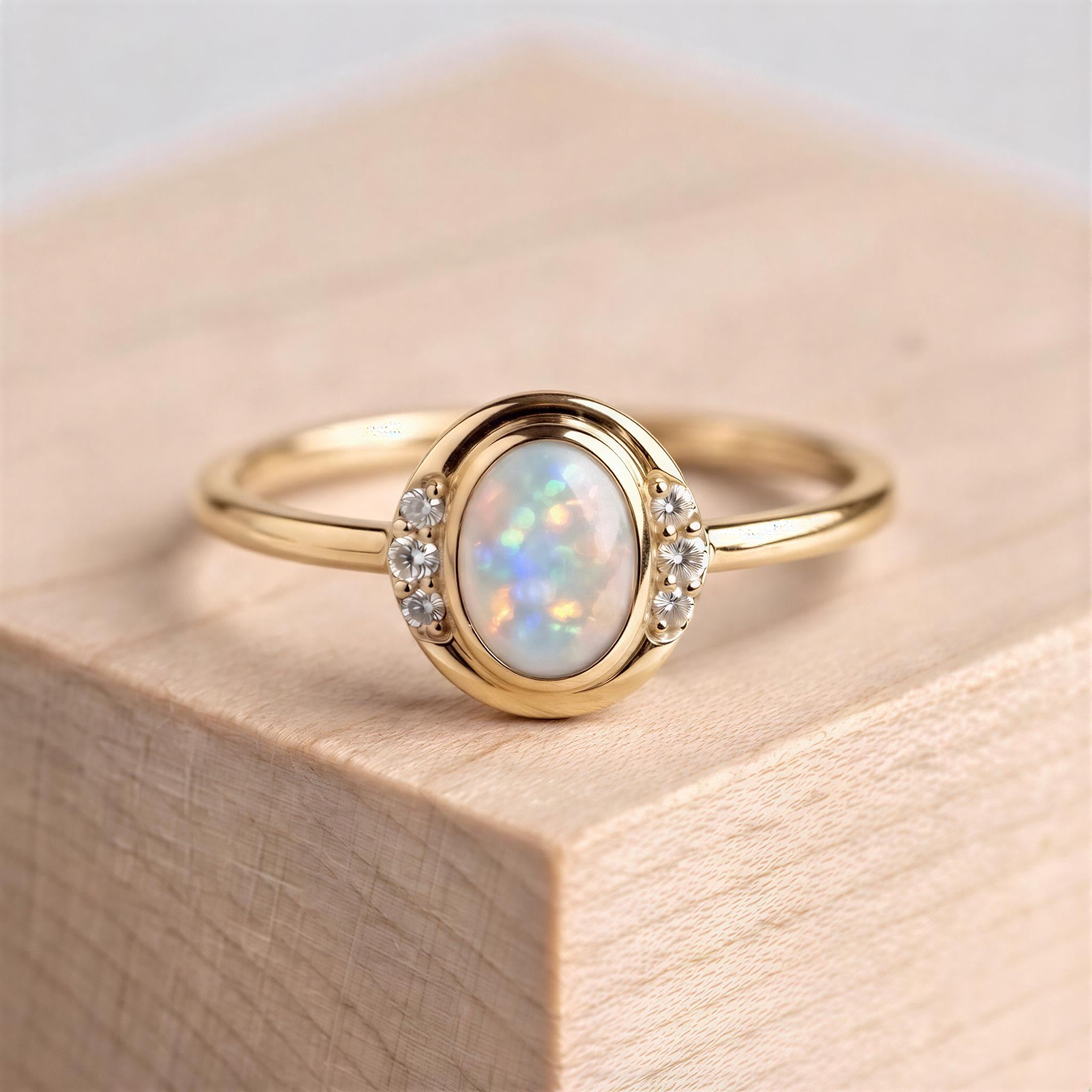 A gold ring with a large oval-shaped opal stone set in the center, surrounded by smaller diamonds.