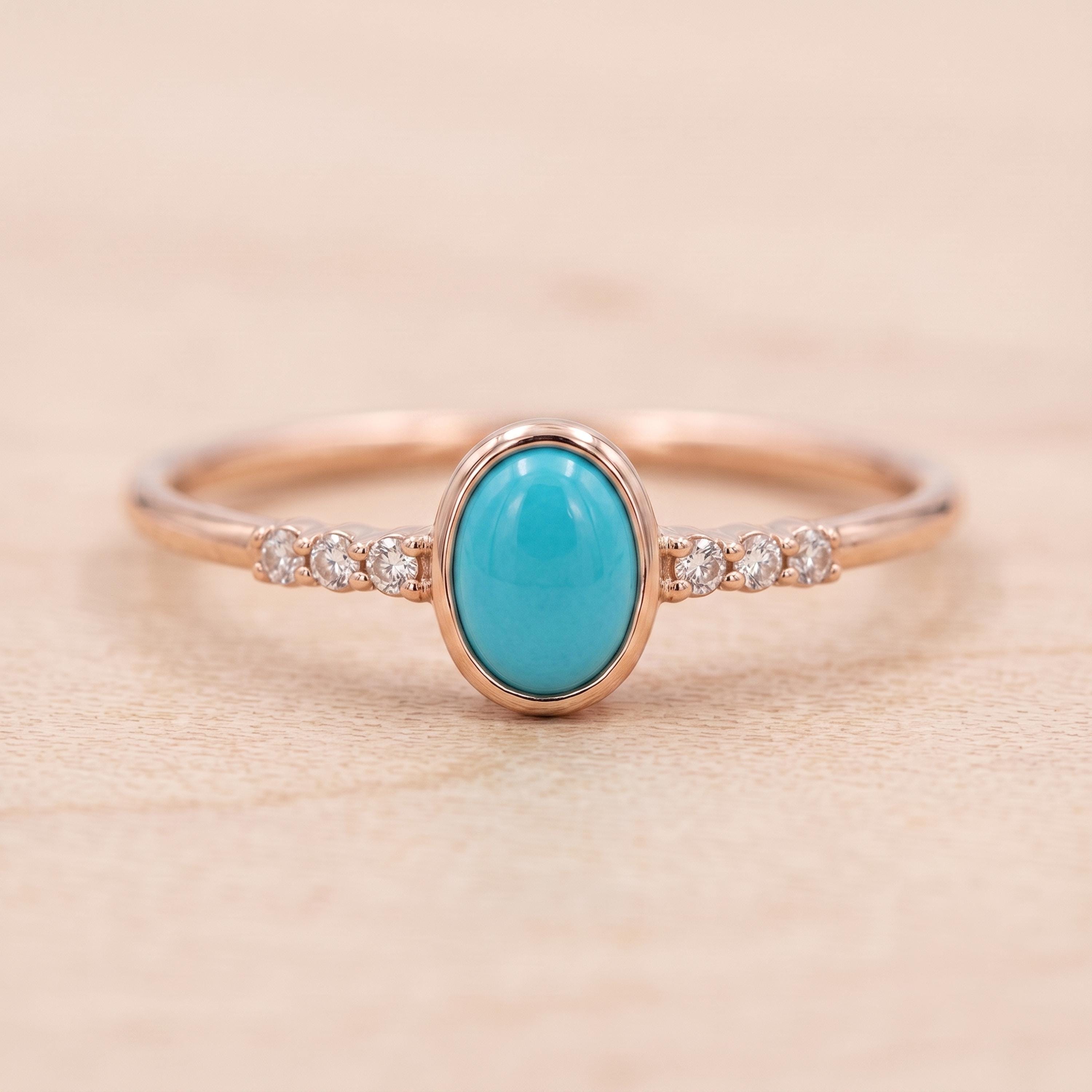 A rose gold ring with a turquoise stone and small diamonds set in the band.