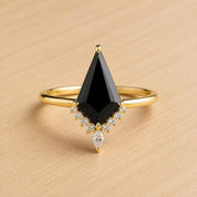 A gold ring with a large black diamond as the centerpiece, surrounded by smaller diamonds.