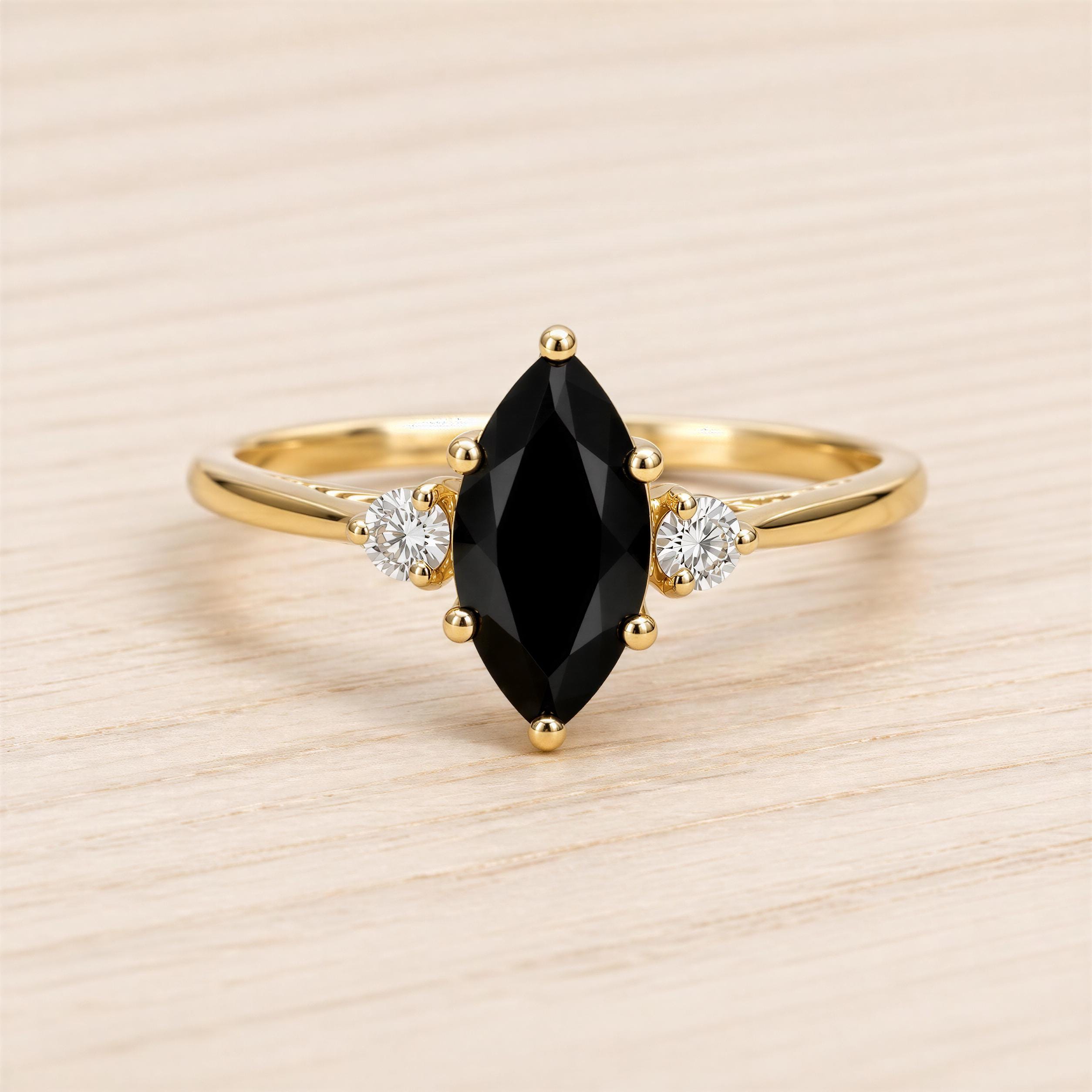 A gold ring with a large black gemstone in the center, surrounded by smaller diamonds.