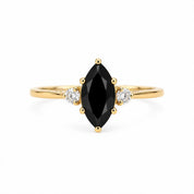 A gold ring with a large black gemstone in the center, surrounded by smaller diamonds.