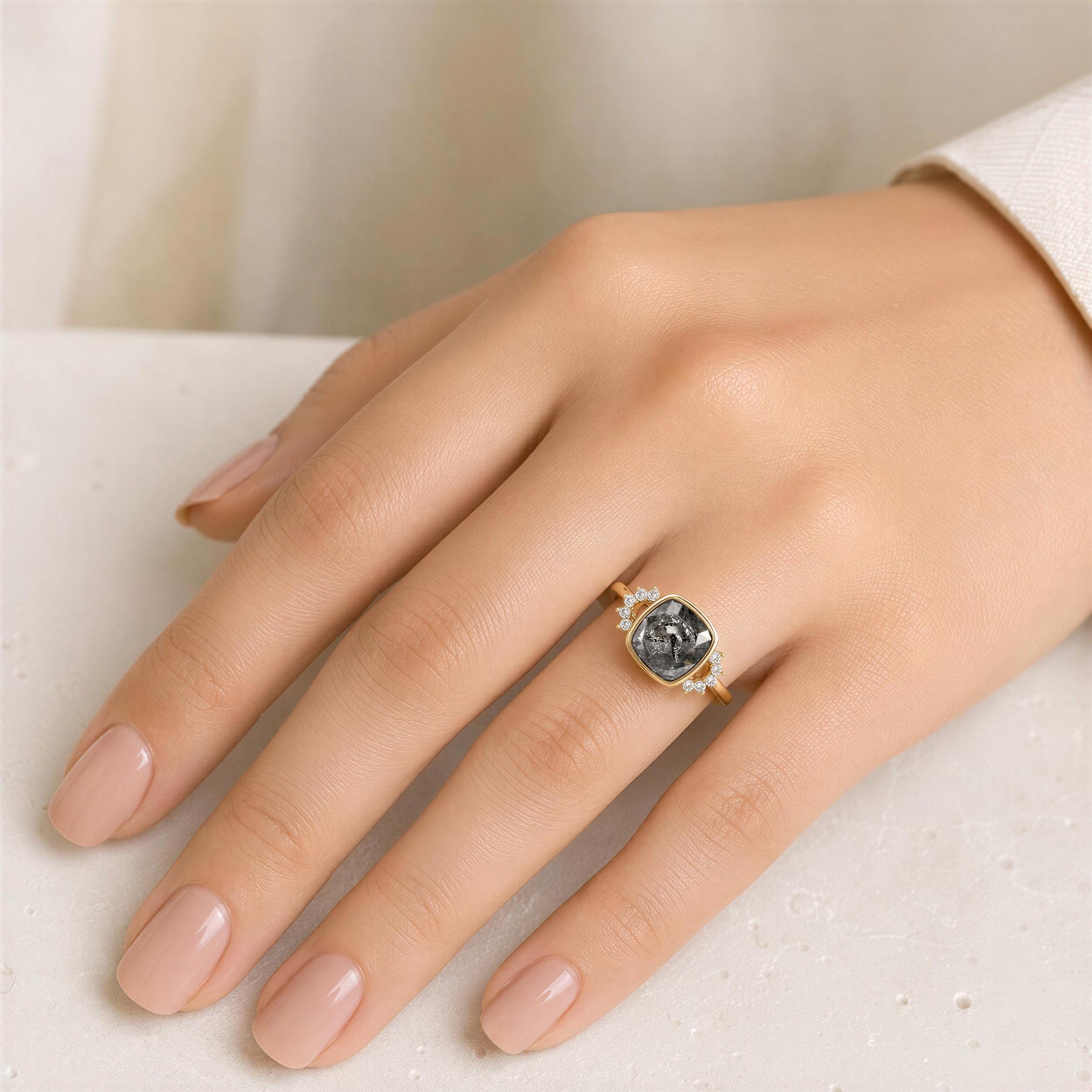 A close-up of a hand wearing a gold ring with a large gray gemstone.