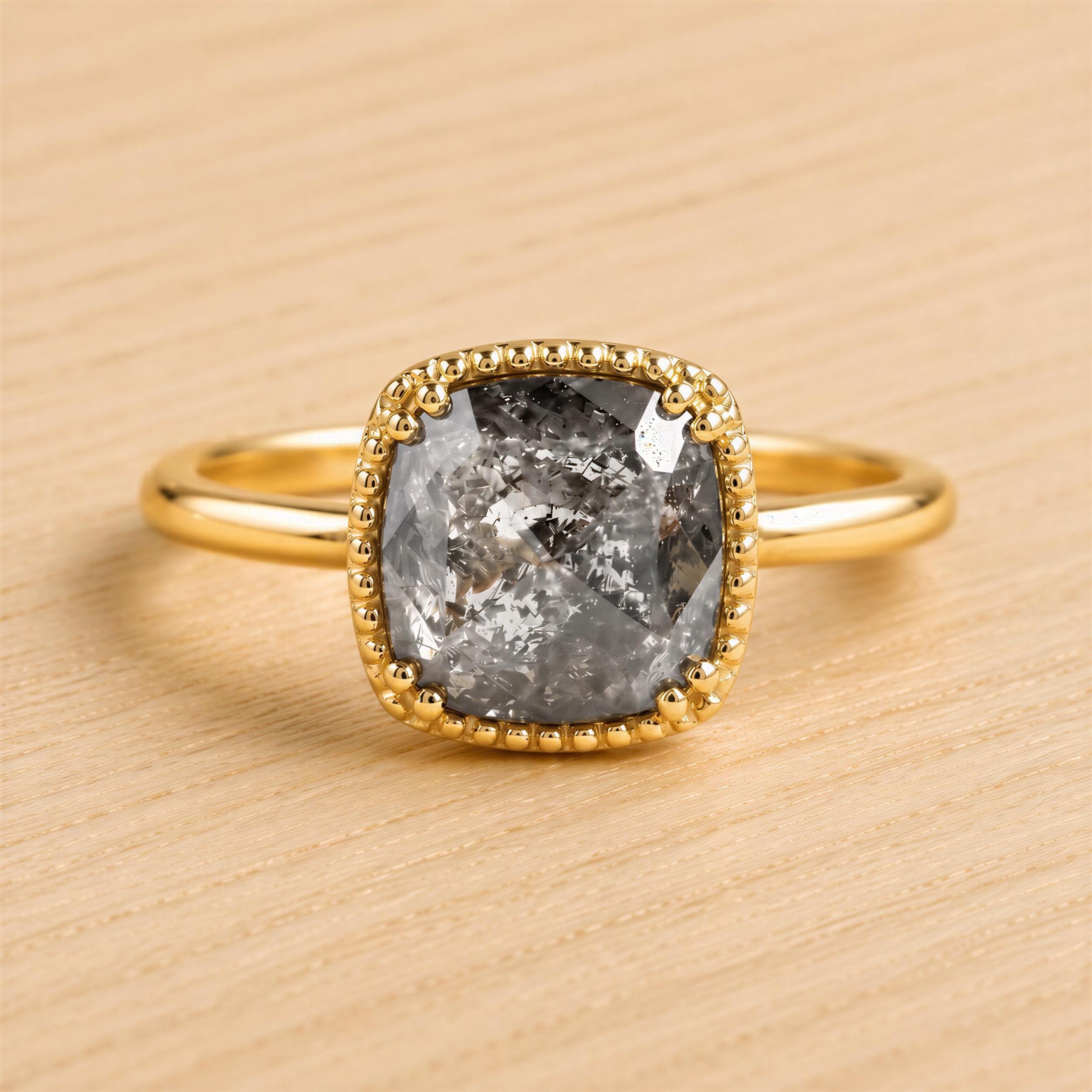 A gold ring with a large, irregularly shaped gray diamond as the centerpiece.