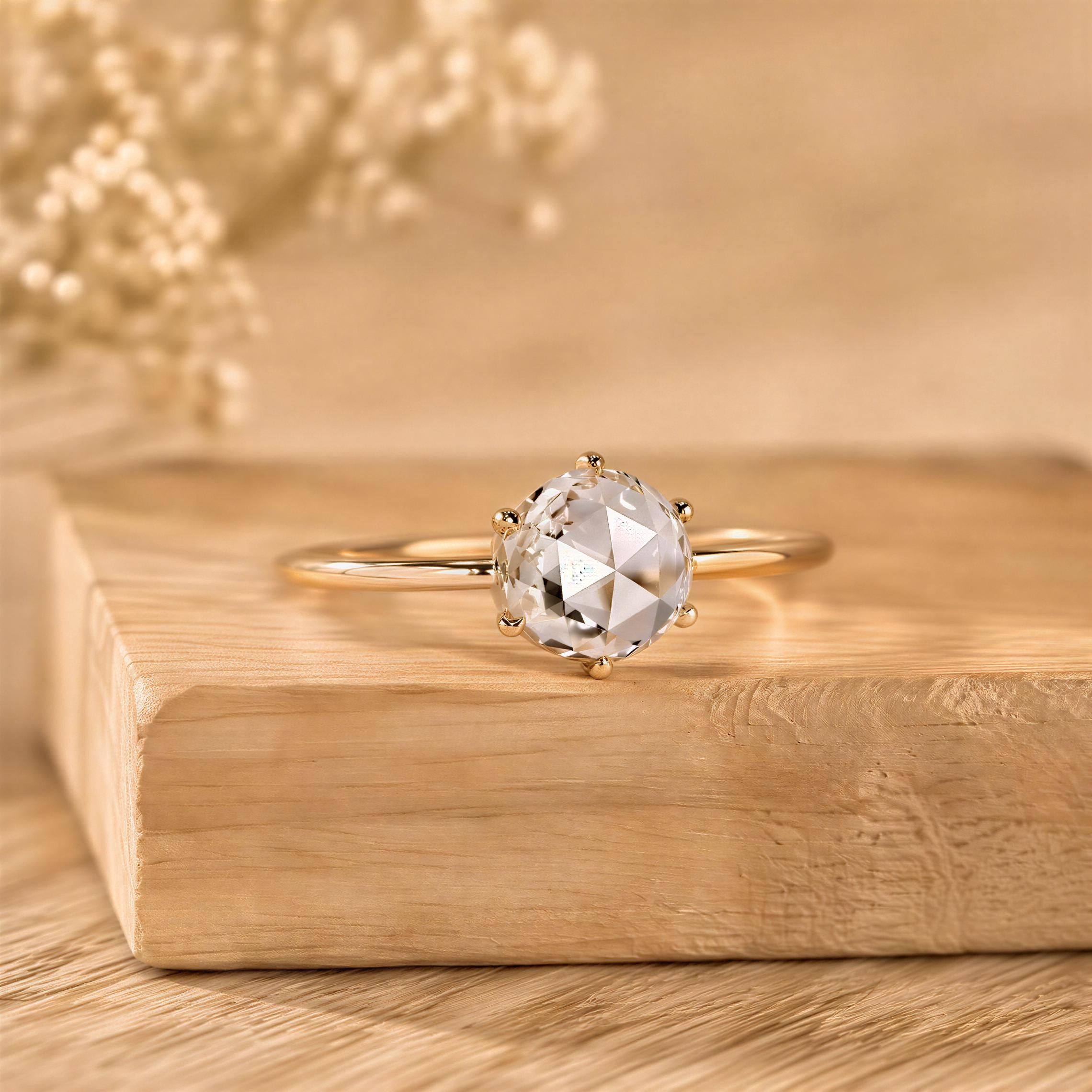 A diamond engagement ring with a large central diamond and smaller diamonds around the edges is displayed on a wooden surface.