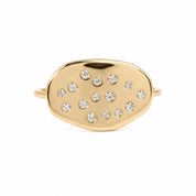 A gold ring with a large oval-shaped stone in the center, surrounded by smaller stones.