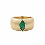 A gold ring with a large oval-shaped green gemstone set in the center.