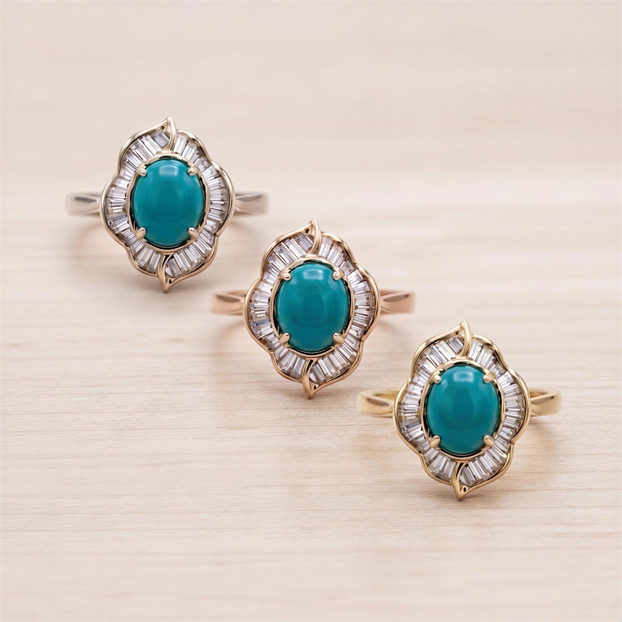 Three gold rings with turquoise gemstones are displayed on a wooden surface.
