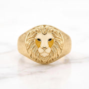 A gold ring with a detailed lion's head design.