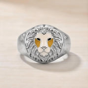 A silver ring with a detailed lion's head design in the center.