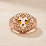A gold ring with a detailed lion's head design on the front.