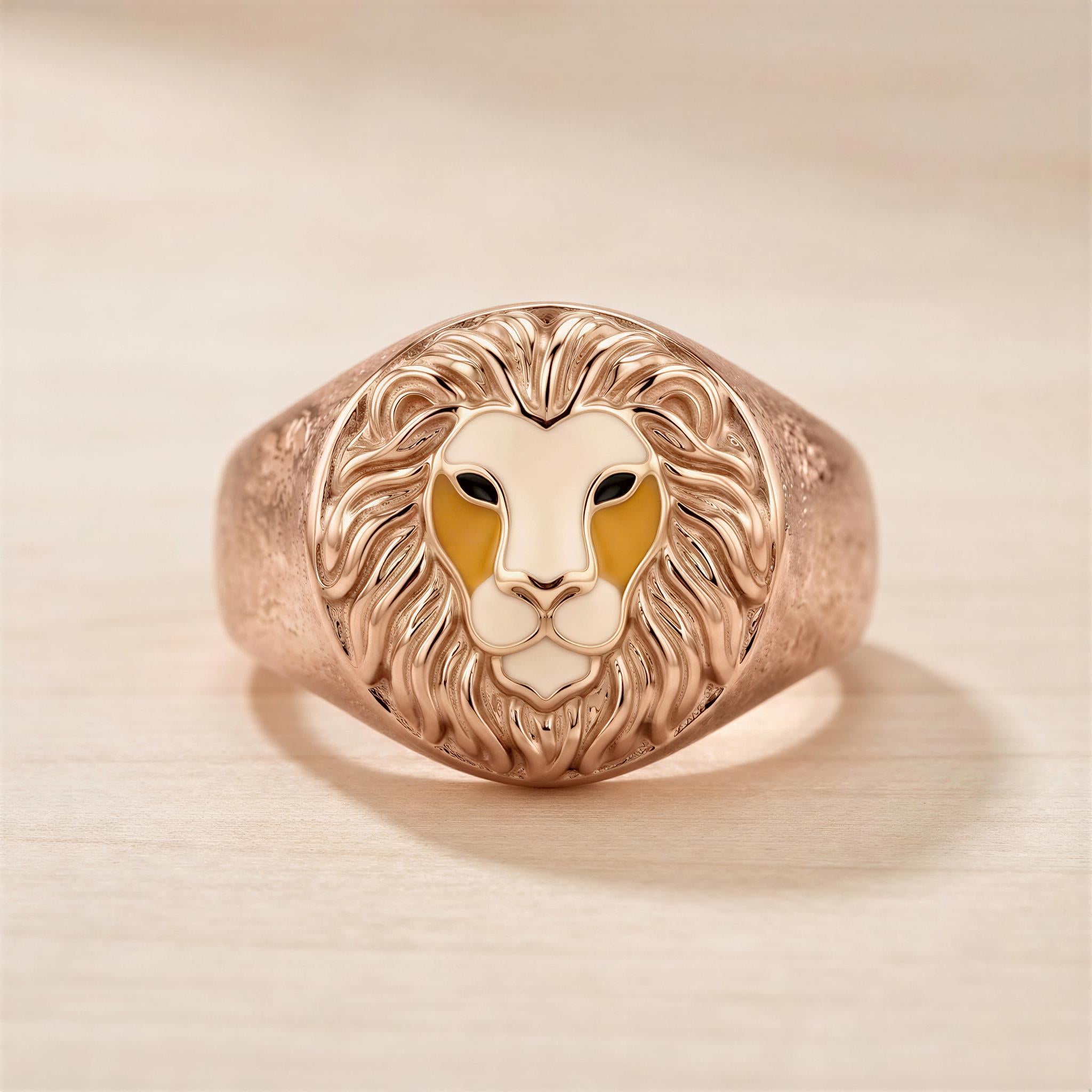A gold ring with a detailed lion's head design on the front.