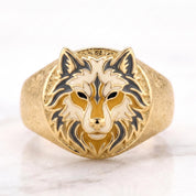 A gold ring with a detailed design of a wolf's head on the front.