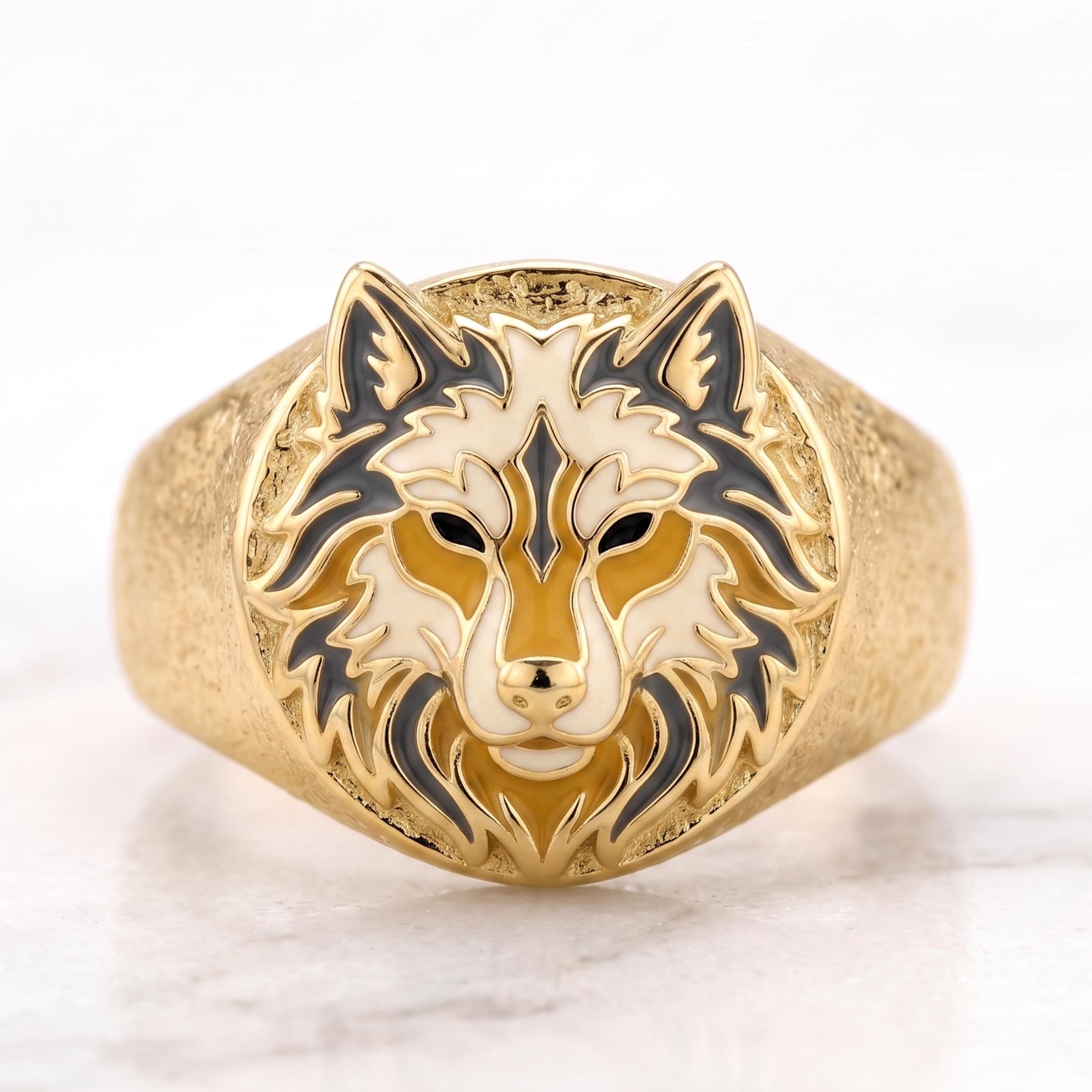 A gold ring with a detailed design of a wolf's head on the front.