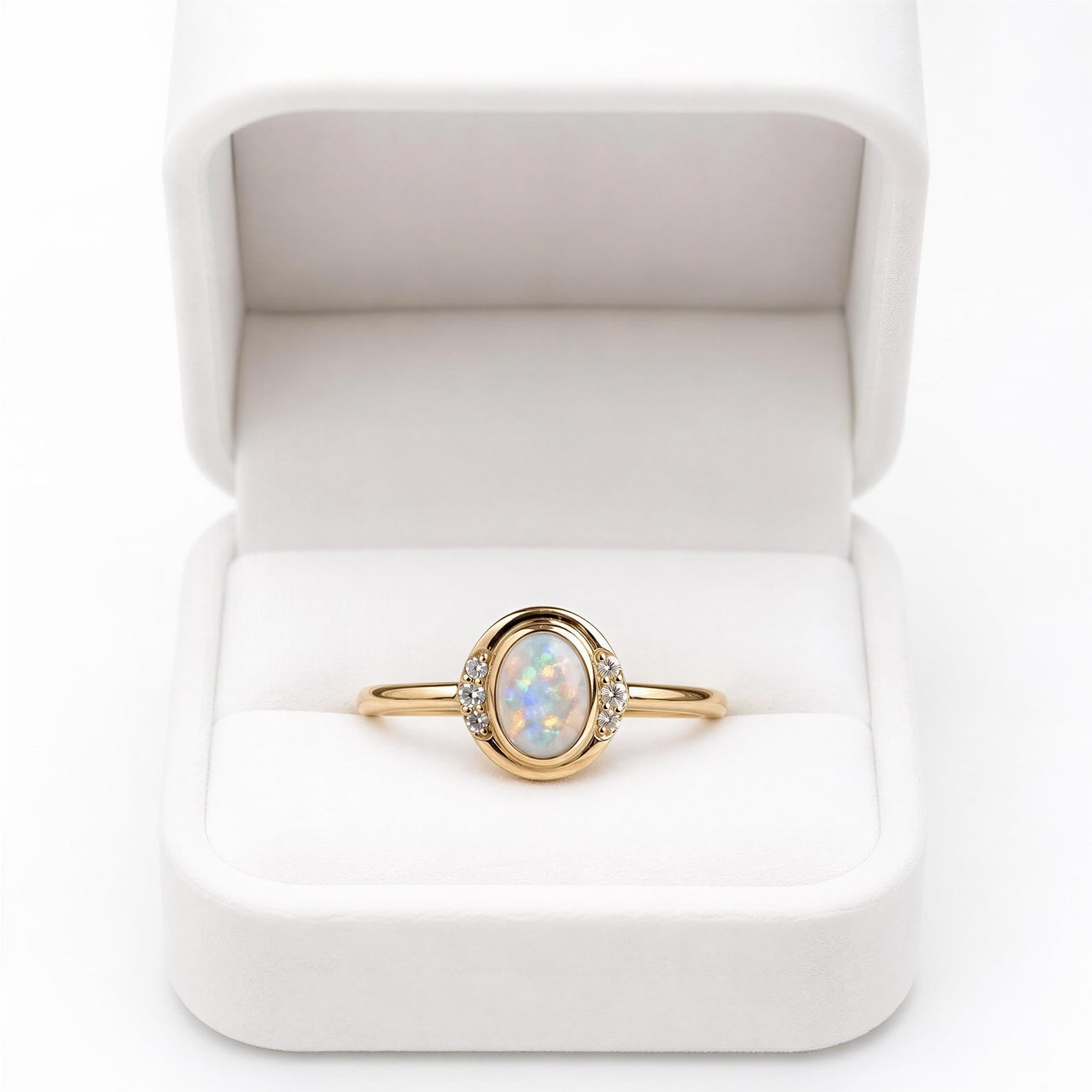 A gold ring with a large oval-shaped opal stone set in the center, displayed in a white jewelry box.