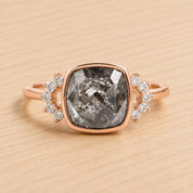 A ring with a large, square-cut diamond as the centerpiece, surrounded by smaller diamonds on either side.