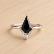 A ring with a large black diamond as the centerpiece, surrounded by smaller diamonds.