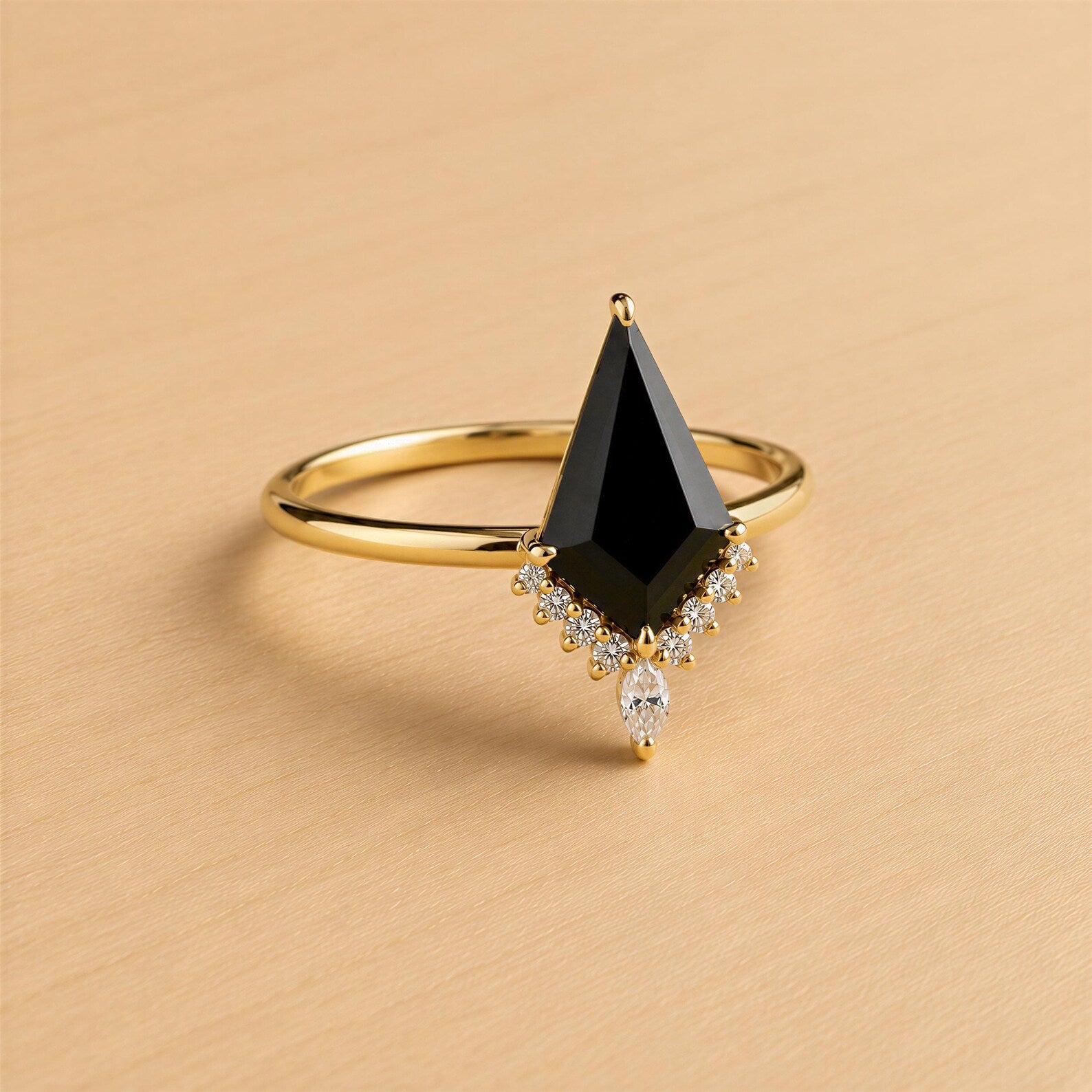 A gold ring with a large black gemstone, possibly a diamond, set in the center.