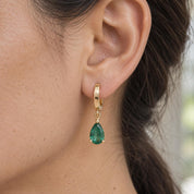 Single emerald drop huggie earring showing scale